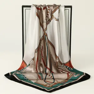 Detailed view of an elegant satin square scarf with a classic luxury chain print pattern