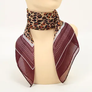 Close-up of elegant leopard print chiffon square scarf with burgundy geometric patterns