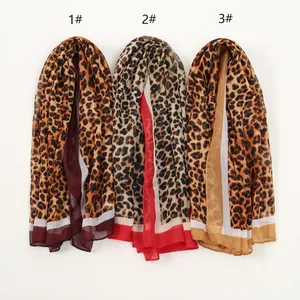 Close-up detail of three elegant leopard print chiffon scarves with colored borders