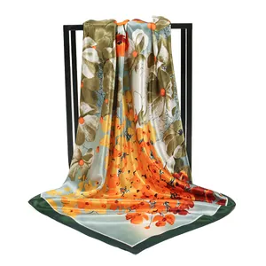 Detailed view of a vibrant floral print satin square scarf with a draped silk texture.