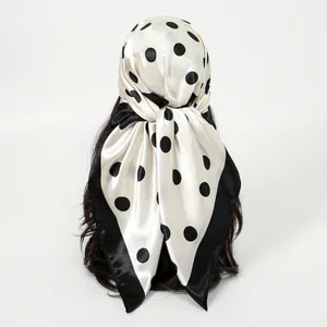 Detailed back view of a white satin square scarf with black polka dots and border.