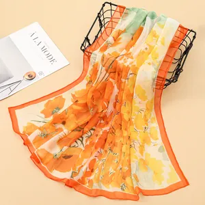 Detail of vibrant orange floral print on a sheer Georgette scarf draped over a basket.