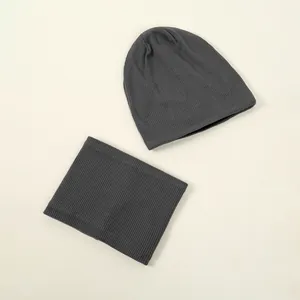 Close-up detail showing the thick ribbed knit texture of the gray beanie and scarf set.