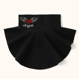 Detail of black false collar with red rhinestone heart and angel wings