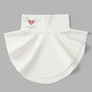 Detail view of the white dickey collar featuring a rhinestone heart and angel design