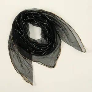 Detailed macro view of sheer black polyester square scarf with sparkling rhinestone waves