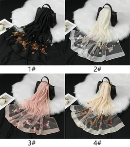 Panoramica dettagliata di quattro sciarpe in organza con ricami floreali eleganti