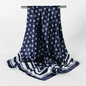 Detail van vintage blauwe satijnen vierkante sjaal met witte stippen en strepen