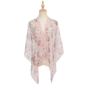 Elegante scialle in chiffon con stampa floreale rosa esposto su un busto di manichino