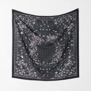 Gesamtansicht eines eleganten Voile-Halstuchs mit floralem Muster an einer weißen Wand