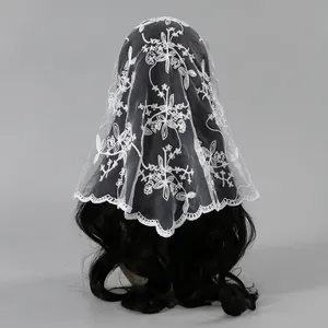 Detailed view of white embroidered floral lace bridal veil displayed on black hair