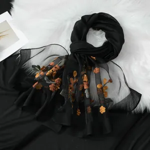 Vista dettagliata della sciarpa in organza nera con ricami floreali e perle eleganti