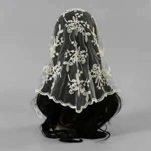 Detailed view of delicate ivory floral embroidery on a lace triangle bridal veil