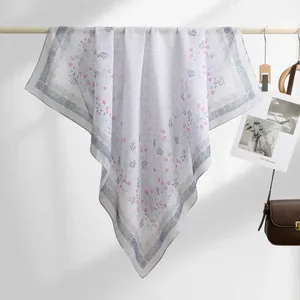 Detailed view of Bali yarn square scarf with pink and blue floral patterns on a white background.