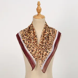 Close-up of stylish leopard print chiffon square scarf elegantly draped on a mannequin.