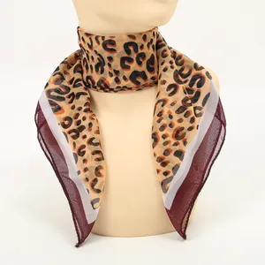 Close-up of leopard print chiffon square scarf with burgundy border on mannequin