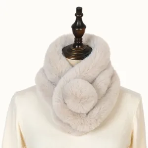 Close-up detail of a soft beige faux rabbit fur winter scarf shown on a mannequin