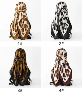 Detailed view showing four color variants of leopard print satin square scarves for headwear