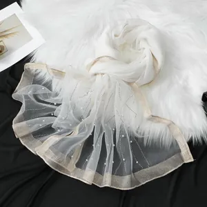 Detailed view of white organza scarf with pearls and sparkling rhinestone ripples