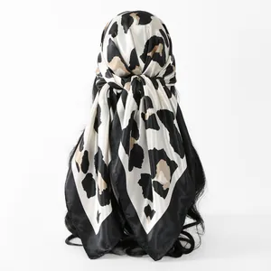Detailed view of an elegant leopard print satin square scarf tied stylishly as a headscarf