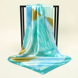 Elegant teal and gold printed satin square scarf with a silky texture and gloss
