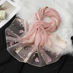 Vue détaillée d'une élégante écharpe en organza rose avec broderie papillon et perles