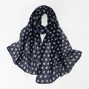 Detailed macro view of the navy blue polka dot chiffon scarf fabric texture.