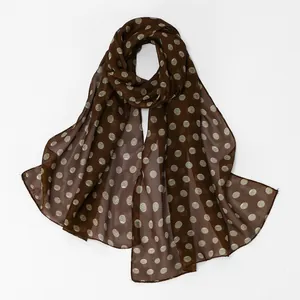 Detailed view of brown chiffon scarf featuring a white textured polka dot pattern