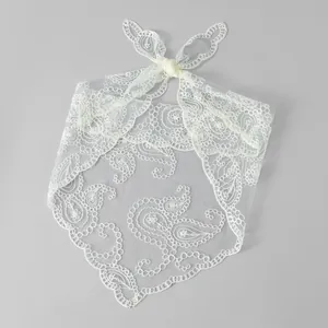 Detailansicht eines weißen Spitzen-Dreieckstuchs mit feiner Paisley-Stickerei und Blumen