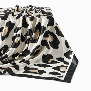 Close-up view of an elegant leopard print satin square scarf with silky sheen texture