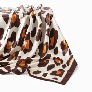 Detail shot of a luxurious leopard print satin square scarf with silky texture drape.