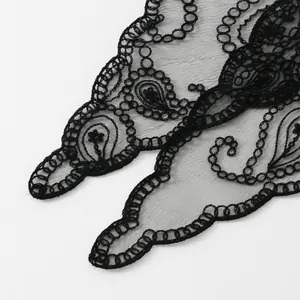 Detaillierte Makroansicht der schwarzen Paisley-Stickerei auf zartem, transparentem Netz