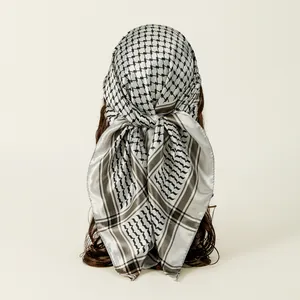 Detailed view of a white satin square scarf with a black Keffiyeh-style plaid pattern