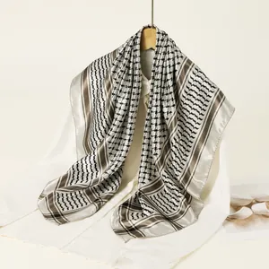 Detailed view of the checkered satin square scarf with soft draping and silky texture.