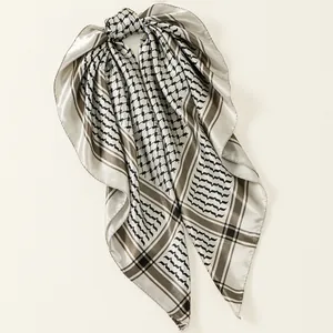 Detailed view of a satin square scarf featuring a classic black and brown grid pattern