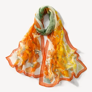 Detailed view of vibrant orange floral print chiffon scarf with lightweight fabric.