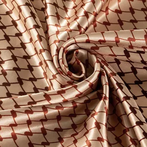 Close-up of satin square scarf with geometric grid pattern and silky texture.