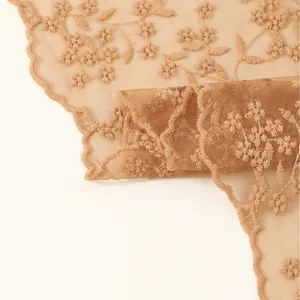 Dettaglio macro di ricamo floreale retrò francese su sciarpa triangolare in pizzo beige
