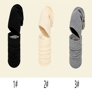 Detailed view of women's knitted beanie hat and neck warmer set in black, beige, and grey colors