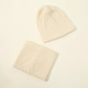 Detailed view of a soft cream knitted beanie hat and matching neck warmer set