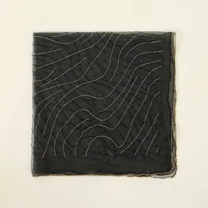 Detailed top-down view of black sheer square scarf with wavy rhinestone patterns