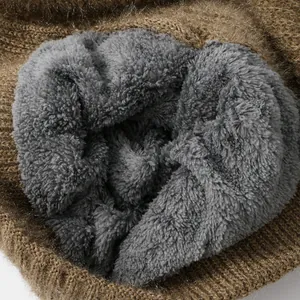 Close-up detail of soft gray fleece lining inside a brown knitted winter hat
