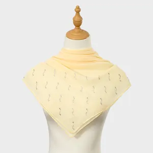 Close-up detail of yellow square chiffon scarf with elegant vertical rhinestone patterns.