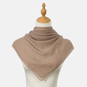 Detail of light brown chiffon square scarf featuring elegant silver rhinestone patterns