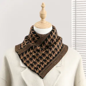 Détail d'un cache-cou tricoté avec motif pied-de-poule et design en triangle pour l'hiver