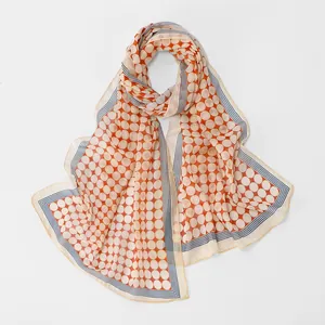 Detail of lightweight chiffon scarf with orange polka dots and blue striped border
