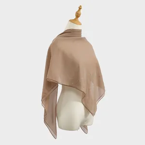 Elegant tan sheer chiffon square scarf with floral rhinestone accents on mannequin