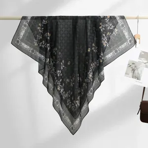Detailed view of the floral print and sheer texture of this elegant black Bali yarn scarf.