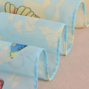 Gedetailleerde macro-opname van lichtblauwe chiffon sjaal met vlinderprint patroon