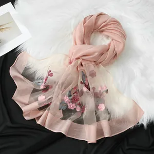 Elegante sciarpa in organza rosa con ricamo floreale su sfondo di pelliccia sintetica